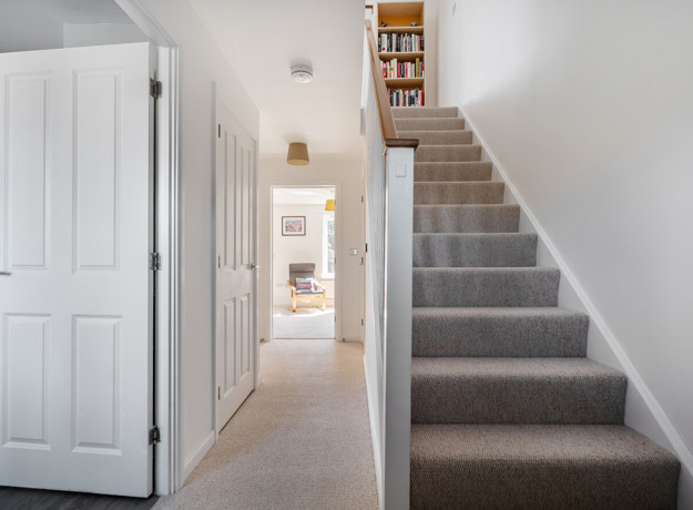 Hallway with staircase, internal doors and view towards the rear of the house.