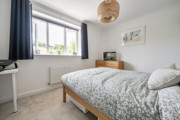 Bedroom with a double bed, bedside furniture and a window.
