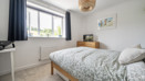 Bedroom with a double bed, bedside furniture and a window.