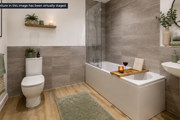 Bathroom at Brickmark Place with modern fittings, bath and shower, vanity unit, and tiled walls.