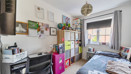 Bedroom with bed, desk, shelving and window with curtains.