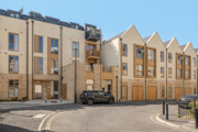 Exterior view of a modern apartment building on a street corner.