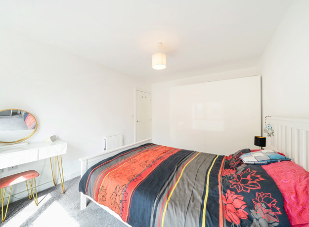 Double bedroom with bed, wardrobe and natural light.