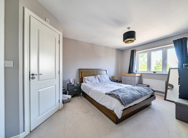 Spacious bedroom with double bed, built-in storage and window
