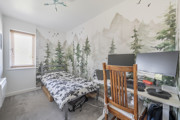 Bedroom with single bed, desk, computer setup and feature wall mural