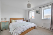 Double bedroom with neutral décor, wooden bed frame and window