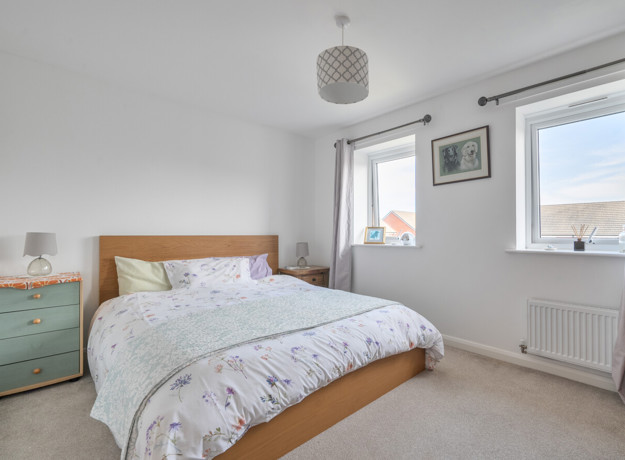 Double bedroom with neutral décor, wooden bed frame and window