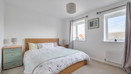 Double bedroom with neutral décor, wooden bed frame and window