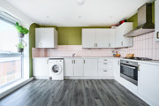 Kitchen with cabinets, oven, washing machine, and countertop appliances.