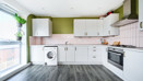 Kitchen with cabinets, oven, washing machine, and countertop appliances.