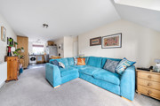 Open-plan living and dining area with blue sofa and kitchen.