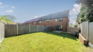 Enclosed rear garden with lawn, fenced boundaries and brick houses beyond