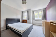 Bedroom with double bed, desk, drawers and window.