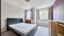 Bedroom with double bed, desk, drawers and window.