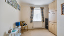 Bedroom with wardrobes, chair, desk and window.