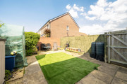 Enclosed rear garden with a lawn, fencing, side gate and neighbouring houses.