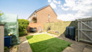 Enclosed rear garden with a lawn, fencing, side gate and neighbouring houses.