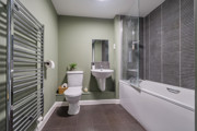 Bathroom with bathtub, shower, toilet, sink and heated towel rail.