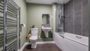 Bathroom with bathtub, shower, toilet, sink and heated towel rail.