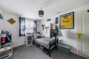 Bedroom with single bed, posters and storage shelves.