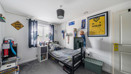 Bedroom with single bed, posters and storage shelves.