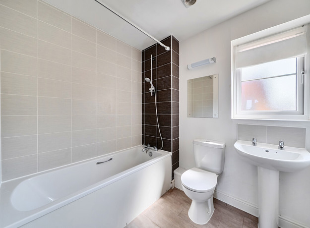 Bathroom with bath, toilet and pedestal sink.