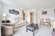 Open-plan living and dining area with sofas, coffee table and dining table.