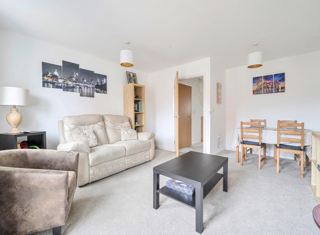 Open-plan living and dining area with sofas, coffee table and dining table.