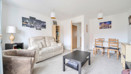Open-plan living and dining area with sofas, coffee table and dining table.