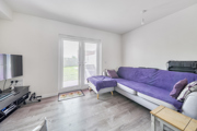 Living room with a purple sofa, TV and patio doors to the garden.