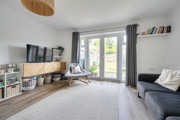 Living room with shelving, seating and patio doors to the garden.