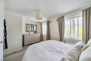 Bedroom with a bed, chest of drawers, mirror and window.