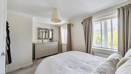 Bedroom with a bed, chest of drawers, mirror and window.