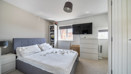 Spacious bedroom with double bed, wall-mounted TV, and neutral decor.