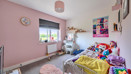 Children's bedroom with single bed, shelving, window and pink wall.