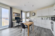 Kitchen and dining area with table, chairs, cabinets, and appliances.