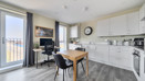 Kitchen and dining area with table, chairs, cabinets, and appliances.