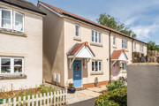 Terraced houses with front gardens, driveways, and paved walkway.