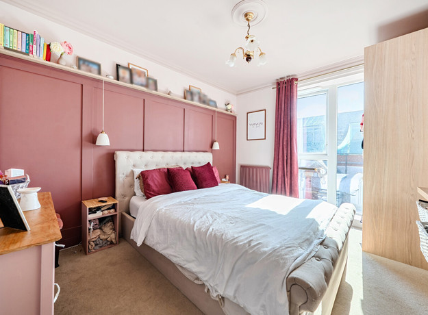 Bedroom with double bed, wardrobe, shelving, and window.