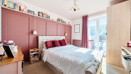 Bedroom with double bed, wardrobe, shelving, and window.