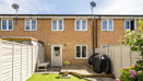 Rear garden with a lawn, patio area and terraced house beyond.