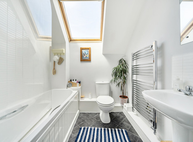 Bathroom with bath, toilet, sink and heated towel rail.
