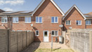 Enclosed rear garden with patio doors, fencing and neighbouring brick houses