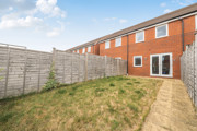 Rear garden with lawn, paved path and fenced boundaries.