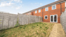 Rear garden with lawn, paved path and fenced boundaries.