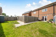 Rear garden with lawn, patio area and surrounding fencing.