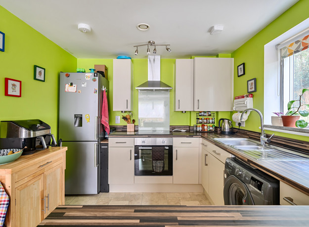 Kitchen with fitted units, appliances and window above the sink.
