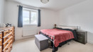 Bedroom with bed, chest of drawers, wardrobe and window with curtains.