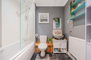 Bathroom with bathtub and shower, toilet, sink unit and tiled floor