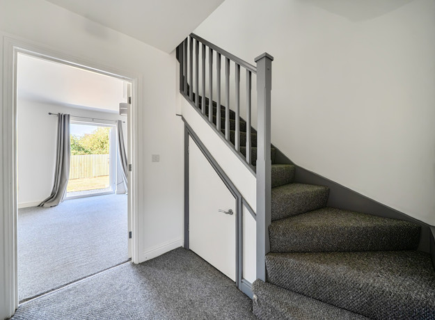 Entrance hall with staircase and doorway to living room.